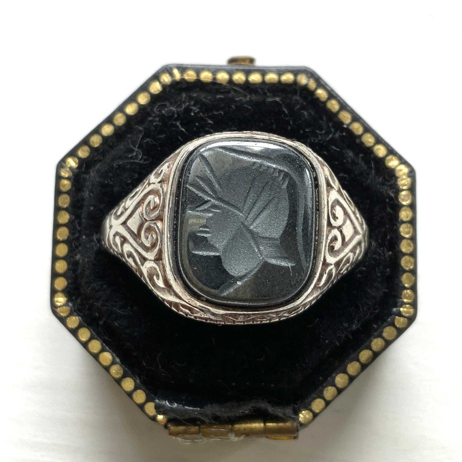 A silver ring set with dark grey, metallic hematite, intaglio-carved with the figure of a Roman warrior. ダークグレーのメタリックなヘマタイトに、ローマ時代の戦士と思われる人物像が沈み彫りされたシルバーリング。