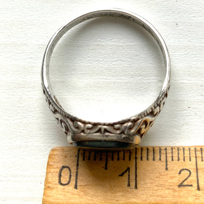 A silver ring set with dark grey, metallic hematite, intaglio-carved with the figure of a Roman warrior. ダークグレーのメタリックなヘマタイトに、ローマ時代の戦士と思われる人物像が沈み彫りされたシルバーリング。