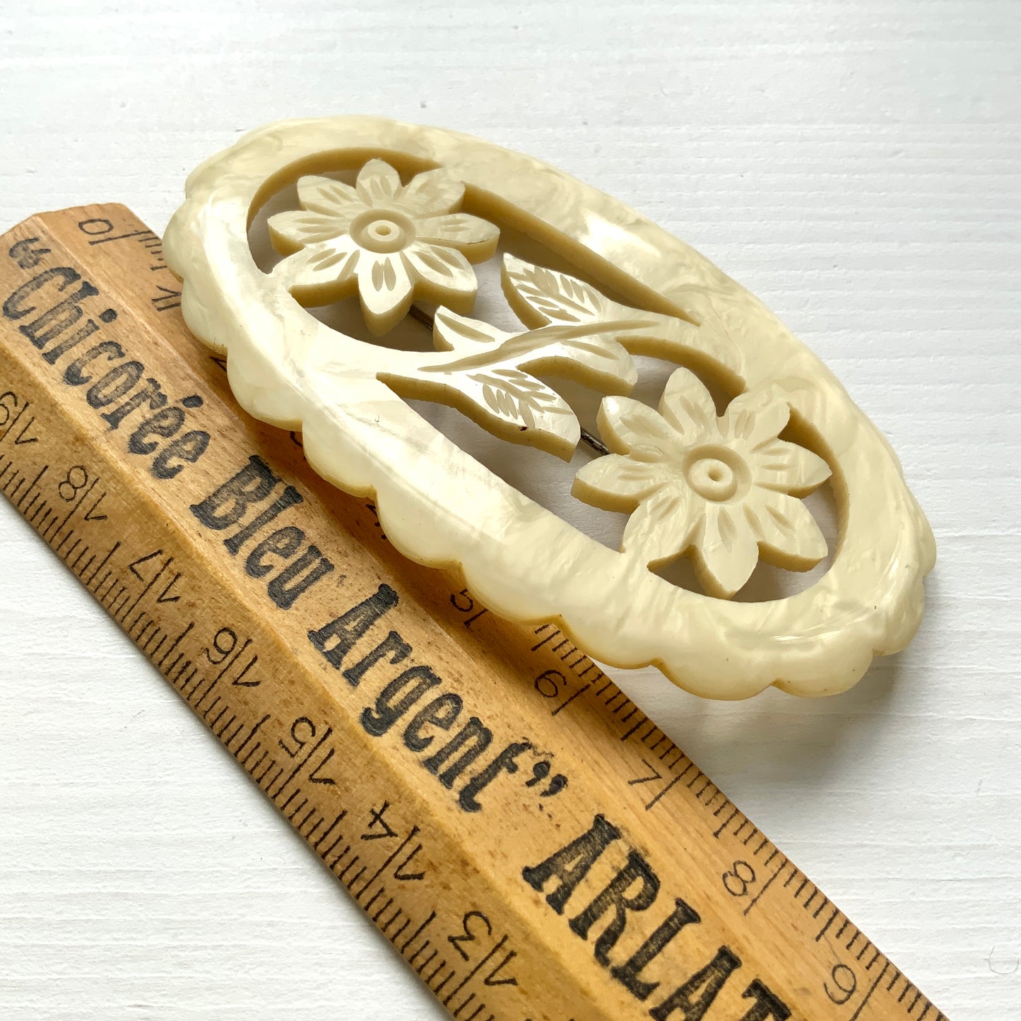 This vintage brooch is crafted from ivory-coloured celluloid in an openwork floral design. アイボリーカラーのセルロイドで作られた、オープンワークのフラワーブローチ。 