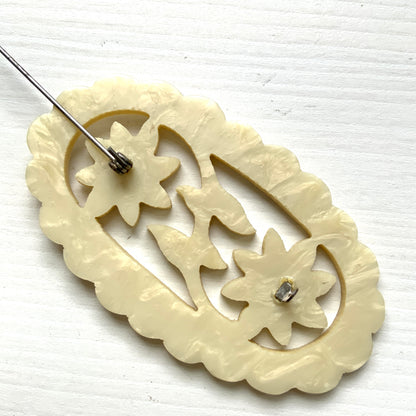 This vintage brooch is crafted from ivory-coloured celluloid in an openwork floral design. アイボリーカラーのセルロイドで作られた、オープンワークのフラワーブローチ。 