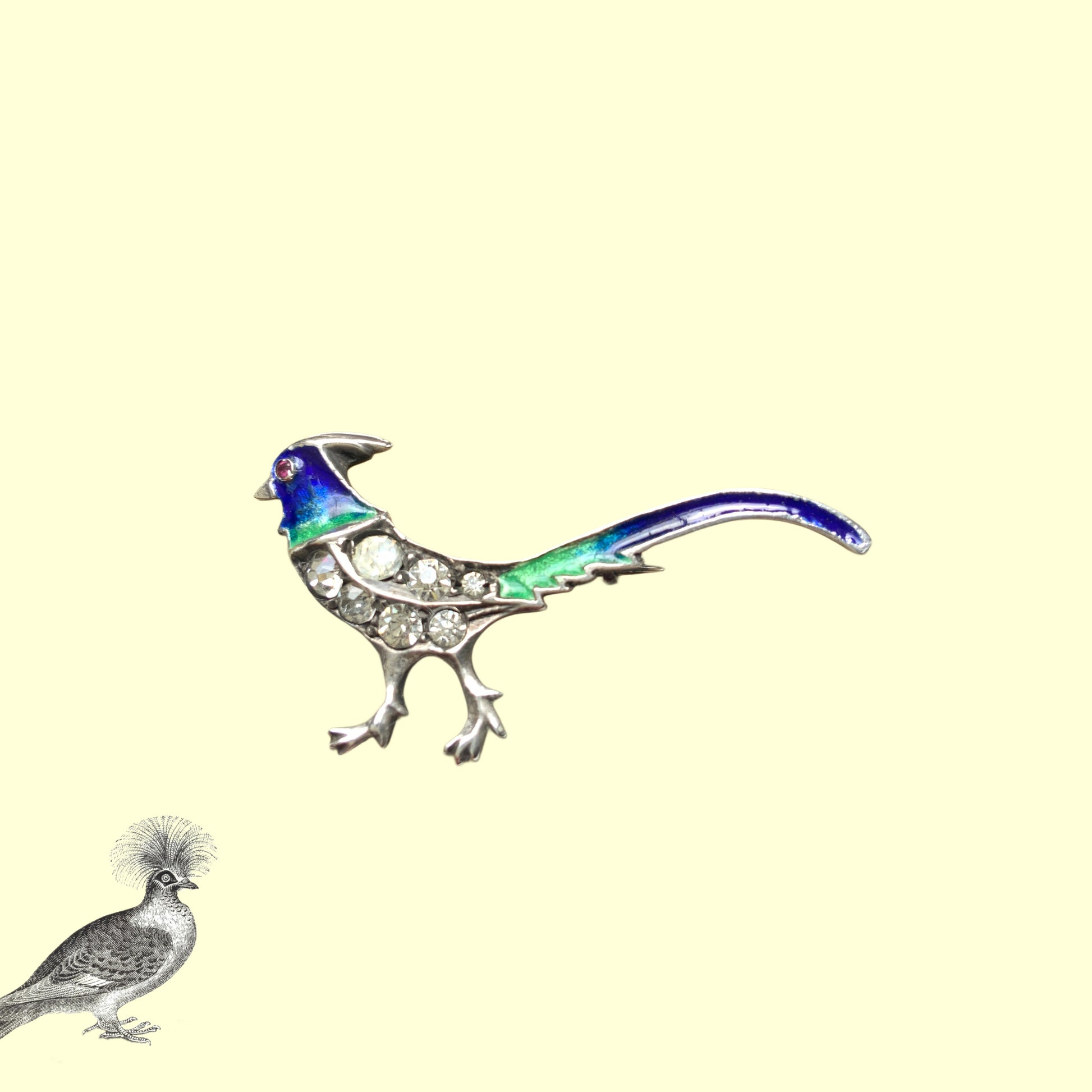 A sterling silver pheasant brooch featuring a beautiful enamel gradient shifting from blue to green.  ブルーからグリーンへと移ろうエナメルのグラデーションが美しい、雉モチーフのシルバーブローチ。