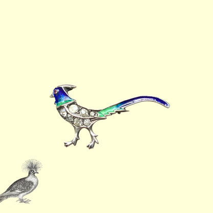 A sterling silver pheasant brooch featuring a beautiful enamel gradient shifting from blue to green.  ブルーからグリーンへと移ろうエナメルのグラデーションが美しい、雉モチーフのシルバーブローチ。