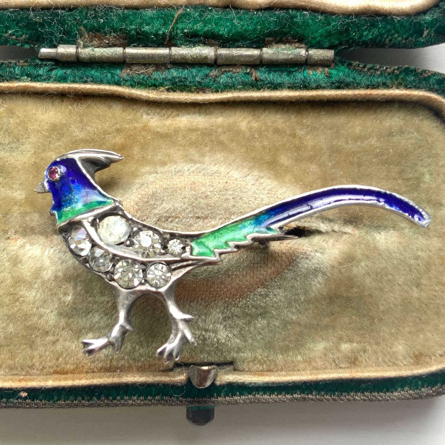 A sterling silver pheasant brooch featuring a beautiful enamel gradient shifting from blue to green.  ブルーからグリーンへと移ろうエナメルのグラデーションが美しい、雉モチーフのシルバーブローチ。
