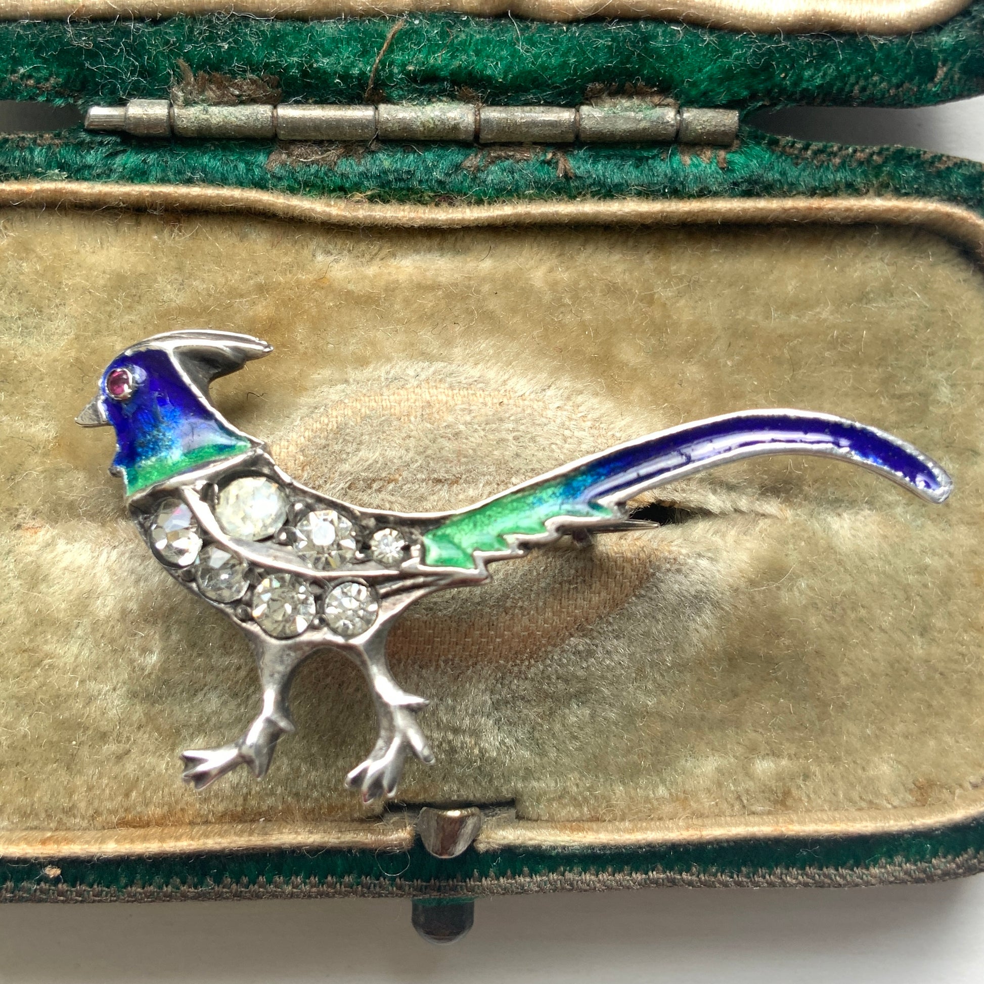 A sterling silver pheasant brooch featuring a beautiful enamel gradient shifting from blue to green.  ブルーからグリーンへと移ろうエナメルのグラデーションが美しい、雉モチーフのシルバーブローチ。
