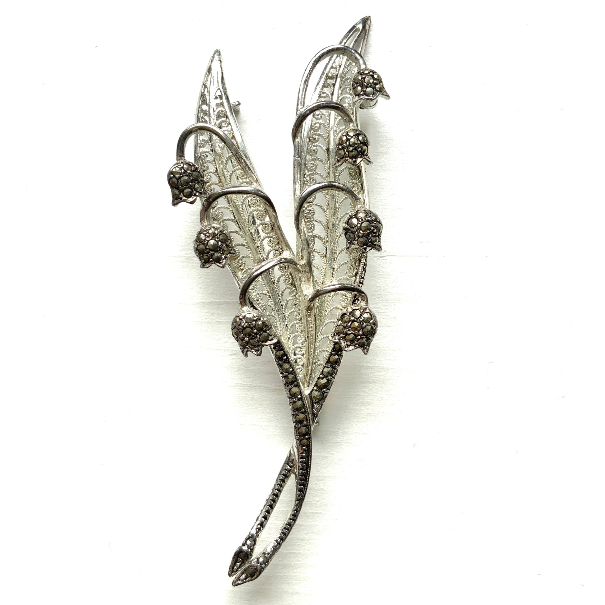 A lily of the valley brooch set with marcasite. マーカサイトがあしらわれたスズランモチーフのブローチ。 