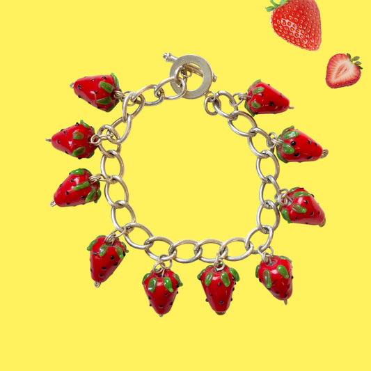 A bracelet with glass strawberry charms that sway from a silver-tone chain. ガラスのストロベリーチャームが揺れるブレスレット。