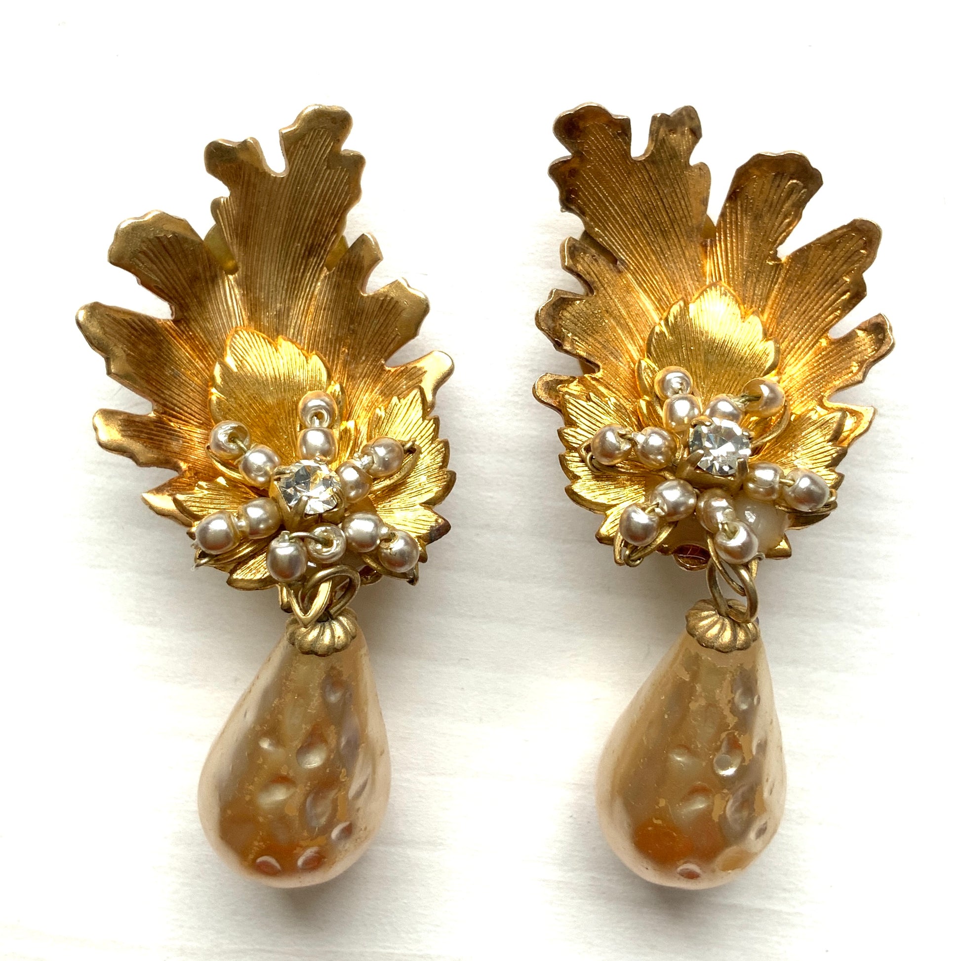 Clip-on earrings featuring gold-tone leaves, tiny pearl flowers, and dangling teardrop glass pearls. ゴールドトーンの美しいリーフに小粒パールのお花と、ティアドロップのグラスパールがゆれるクリップイヤリング。