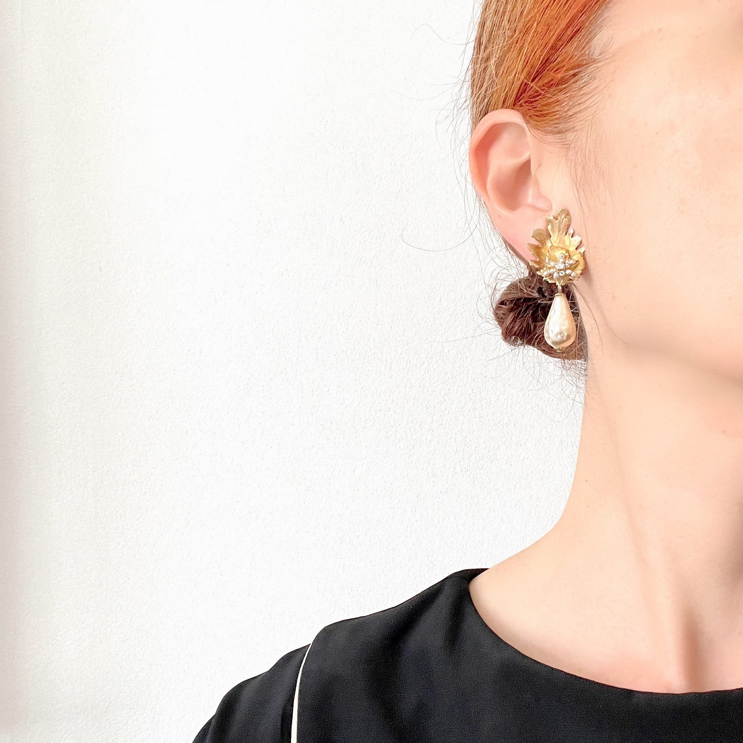 Clip-on earrings featuring gold-tone leaves, tiny pearl flowers, and dangling teardrop glass pearls. ゴールドトーンの美しいリーフに小粒パールのお花と、ティアドロップのグラスパールがゆれるクリップイヤリング。