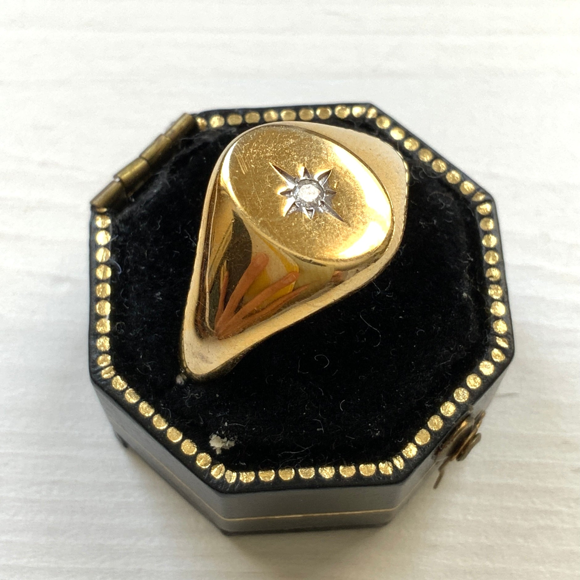 A gold-plated silver ring featuring an oval signet with a single clear stone sparkling at the centre. 楕円のシグネットにクリアストーンが一粒きらりと輝く金メッキされたシルバーリング。 