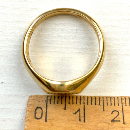 A gold-plated silver ring featuring an oval signet with a single clear stone sparkling at the centre. 楕円のシグネットにクリアストーンが一粒きらりと輝く金メッキされたシルバーリング。 