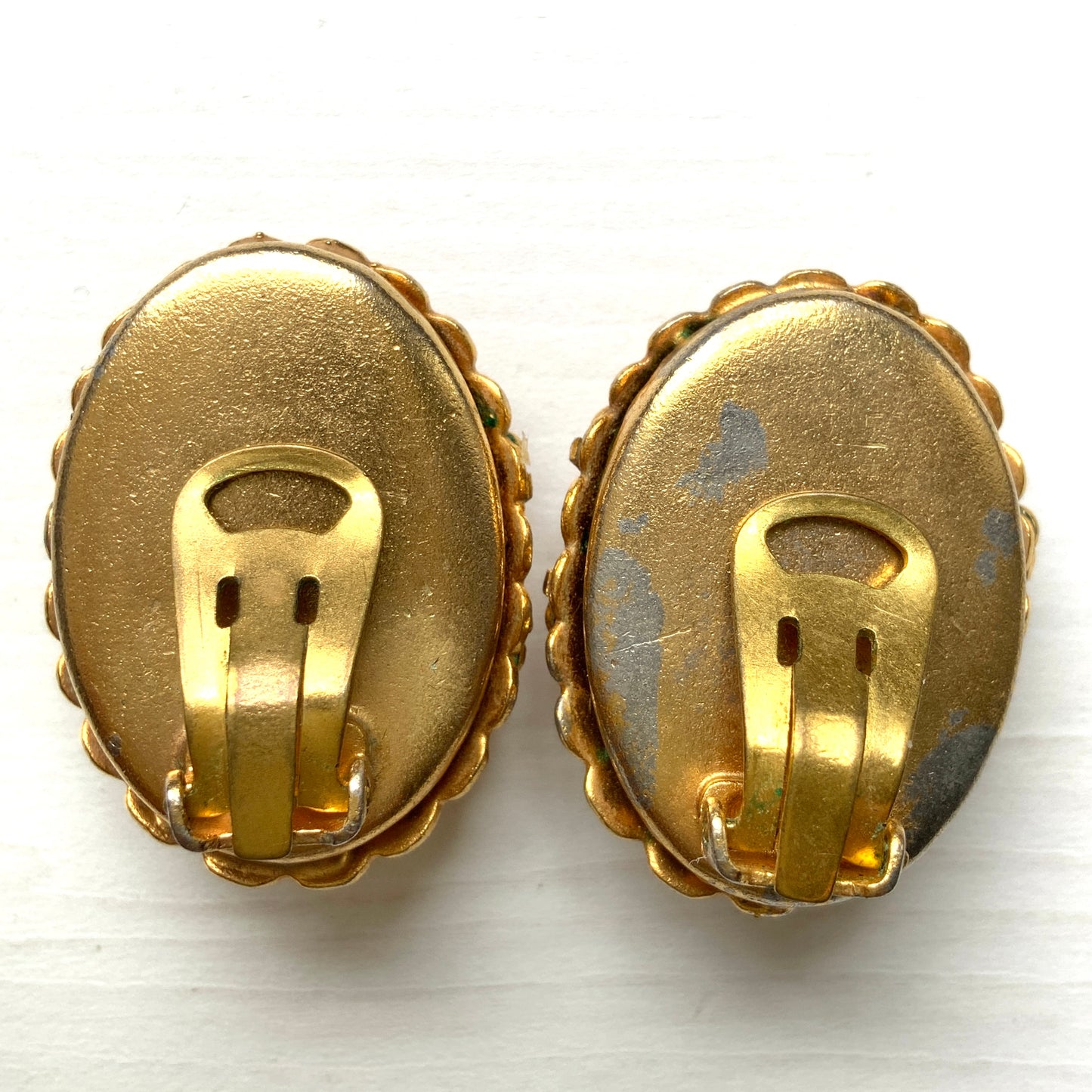 Vibrant blue lapis glass clip-on earrings set in gold-tone metal frames. 鮮やかなブルーのラピスグラスが、ゴールドトーンメタルのフレームに収められたクリップイヤリング。 