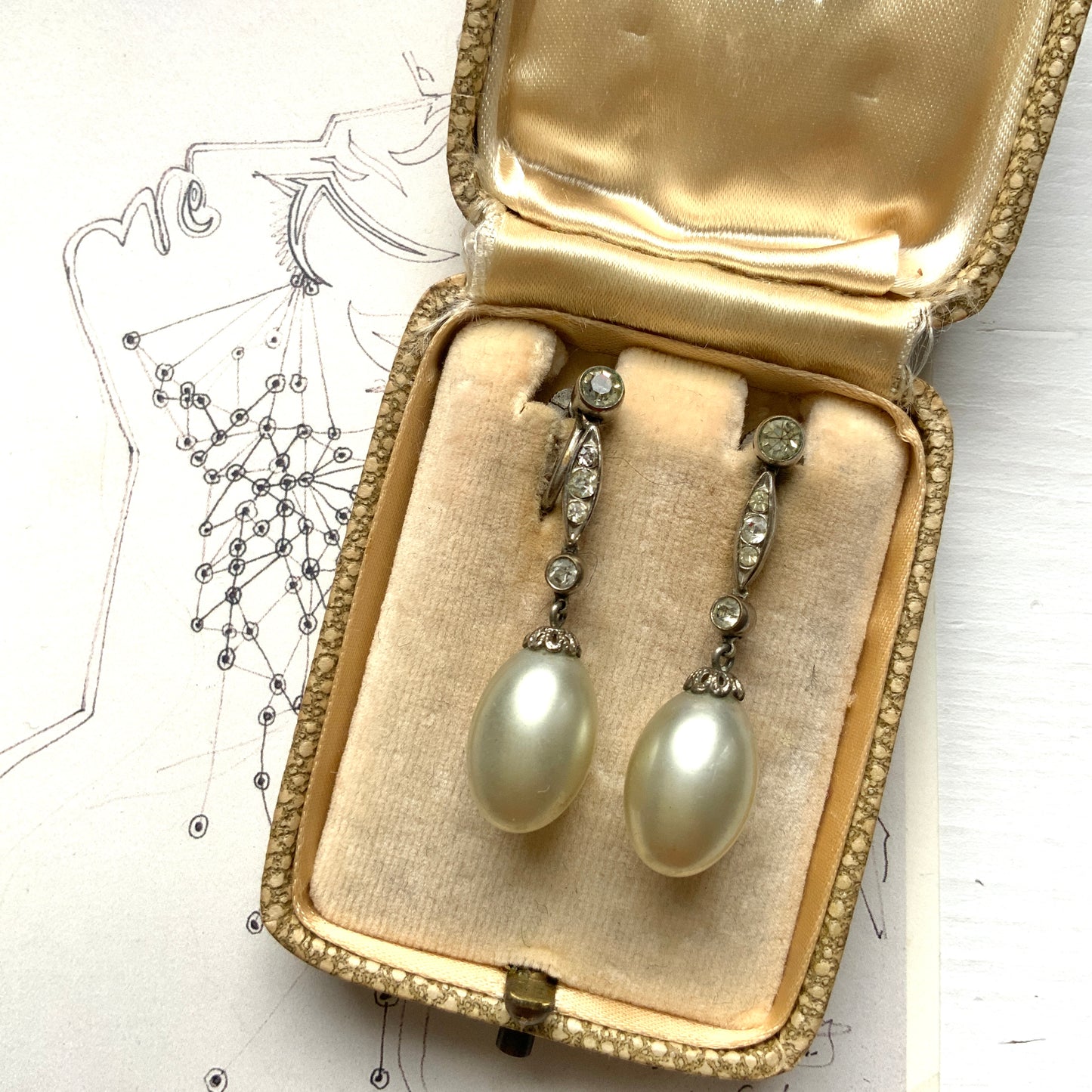  Screw-back earrings featuring oval-shaped glass pearls with a subtle silver-grey tint. うっすらとシルバー/グレーみがかかったオーバル型のグラスパールが揺れるスクリューイヤリング。