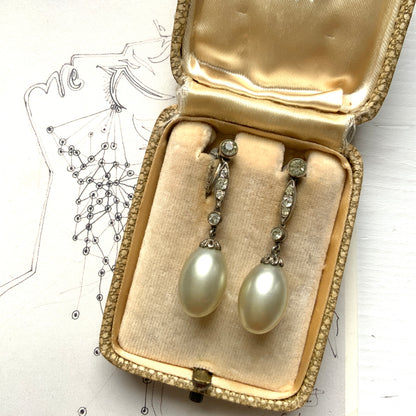  Screw-back earrings featuring oval-shaped glass pearls with a subtle silver-grey tint. うっすらとシルバー/グレーみがかかったオーバル型のグラスパールが揺れるスクリューイヤリング。