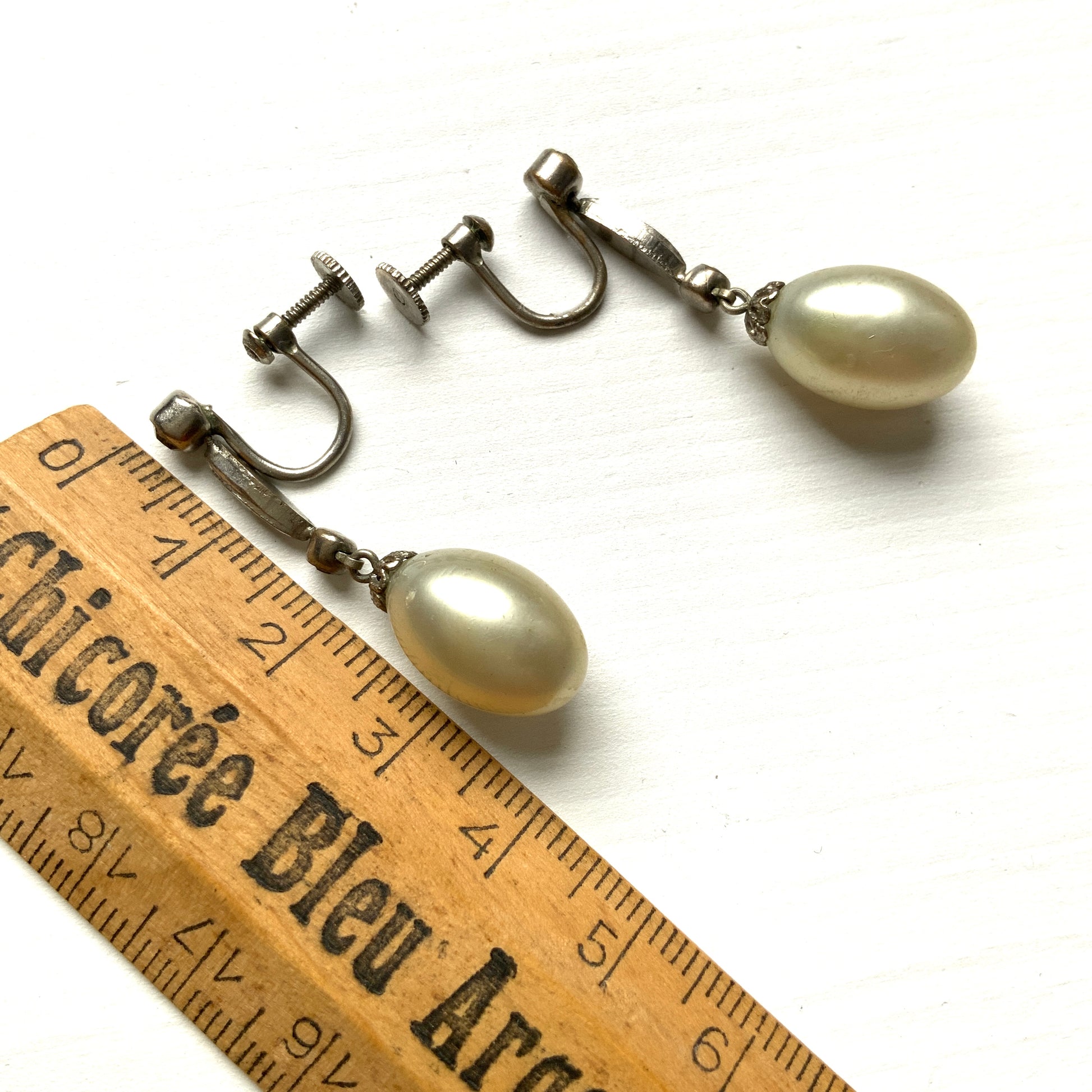  Screw-back earrings featuring oval-shaped glass pearls with a subtle silver-grey tint. うっすらとシルバー/グレーみがかかったオーバル型のグラスパールが揺れるスクリューイヤリング。