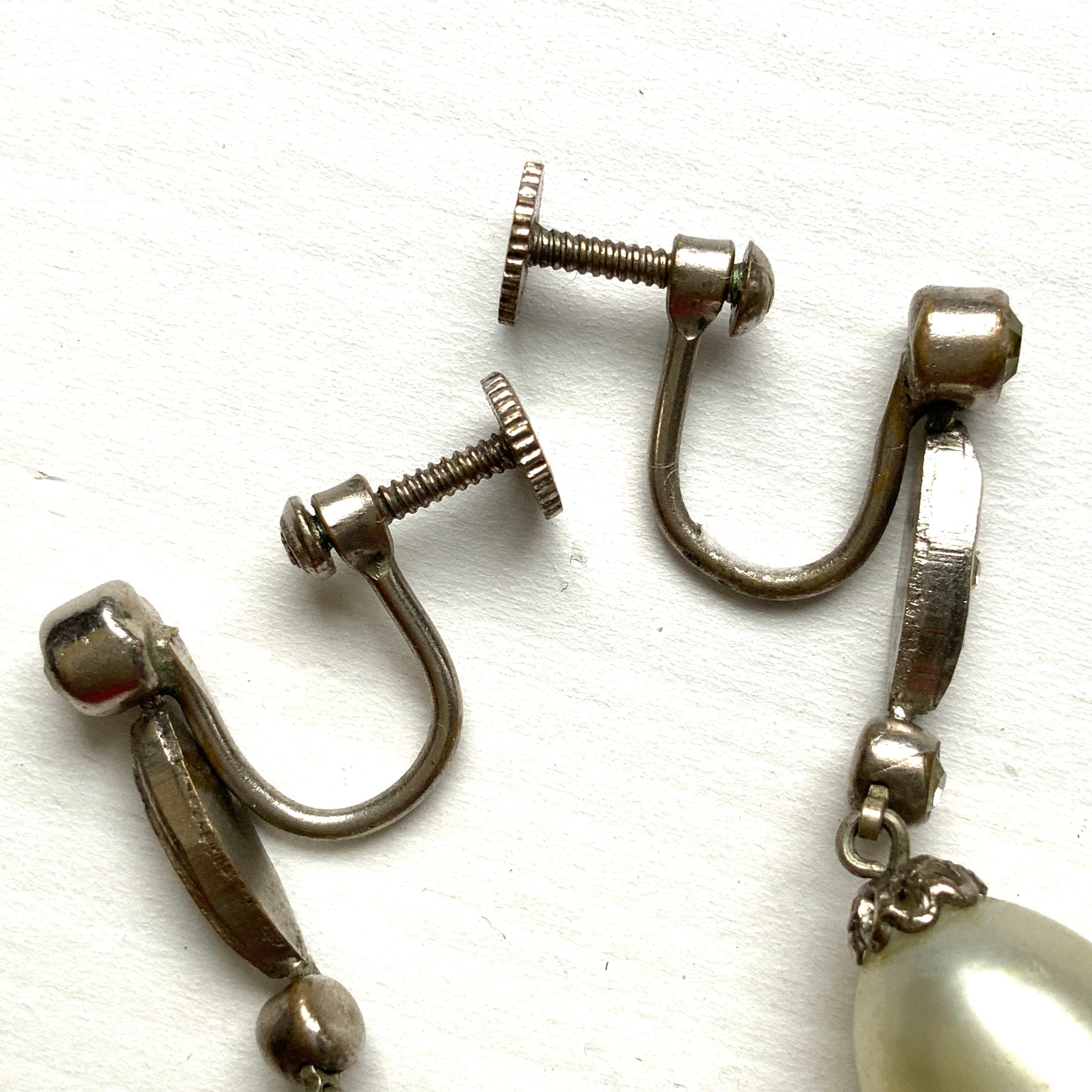  Screw-back earrings featuring oval-shaped glass pearls with a subtle silver-grey tint. うっすらとシルバー/グレーみがかかったオーバル型のグラスパールが揺れるスクリューイヤリング。
