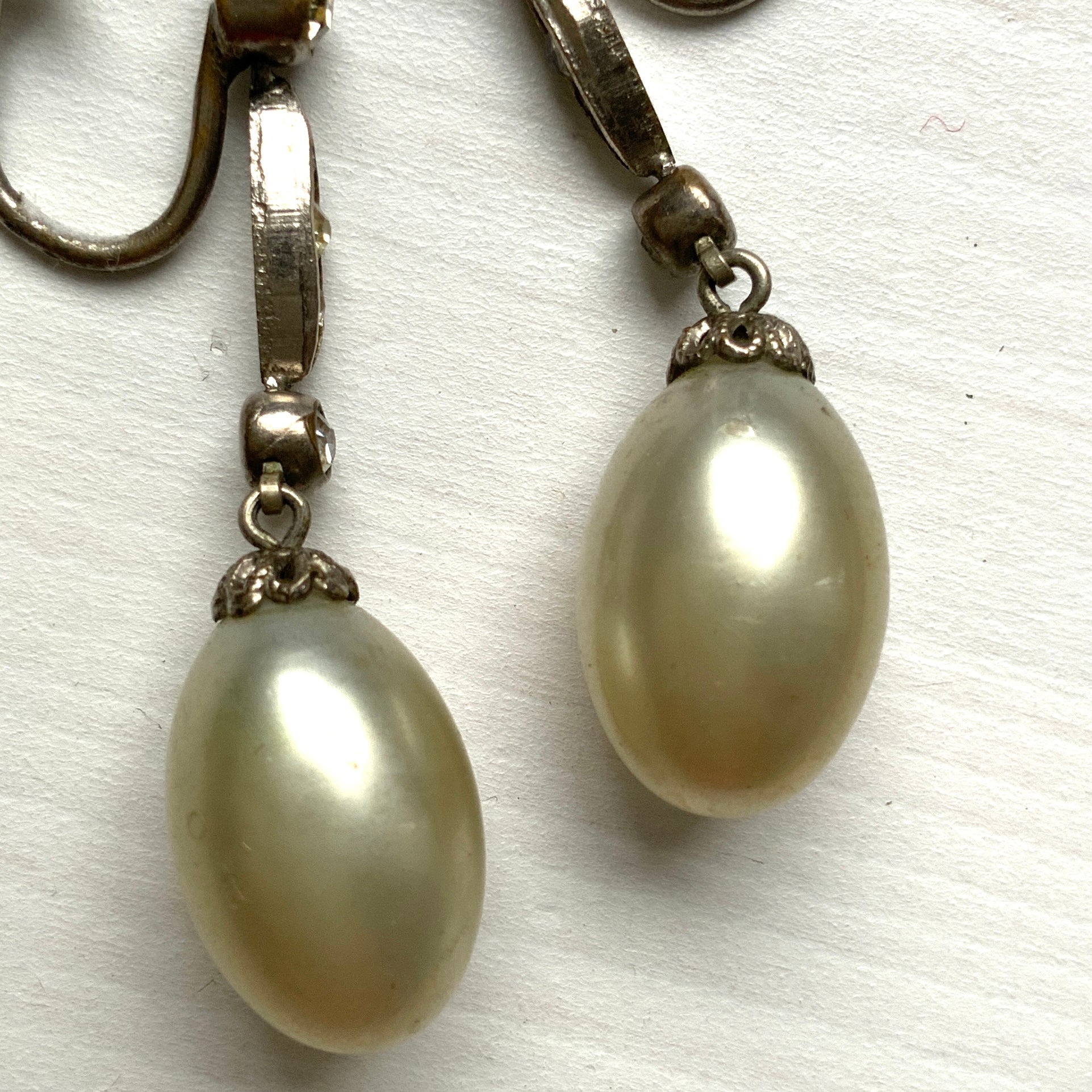  Screw-back earrings featuring oval-shaped glass pearls with a subtle silver-grey tint. うっすらとシルバー/グレーみがかかったオーバル型のグラスパールが揺れるスクリューイヤリング。