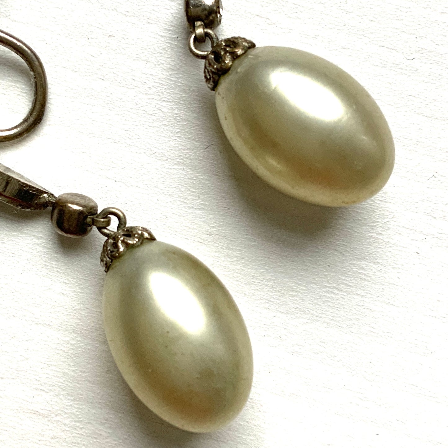  Screw-back earrings featuring oval-shaped glass pearls with a subtle silver-grey tint. うっすらとシルバー/グレーみがかかったオーバル型のグラスパールが揺れるスクリューイヤリング。
