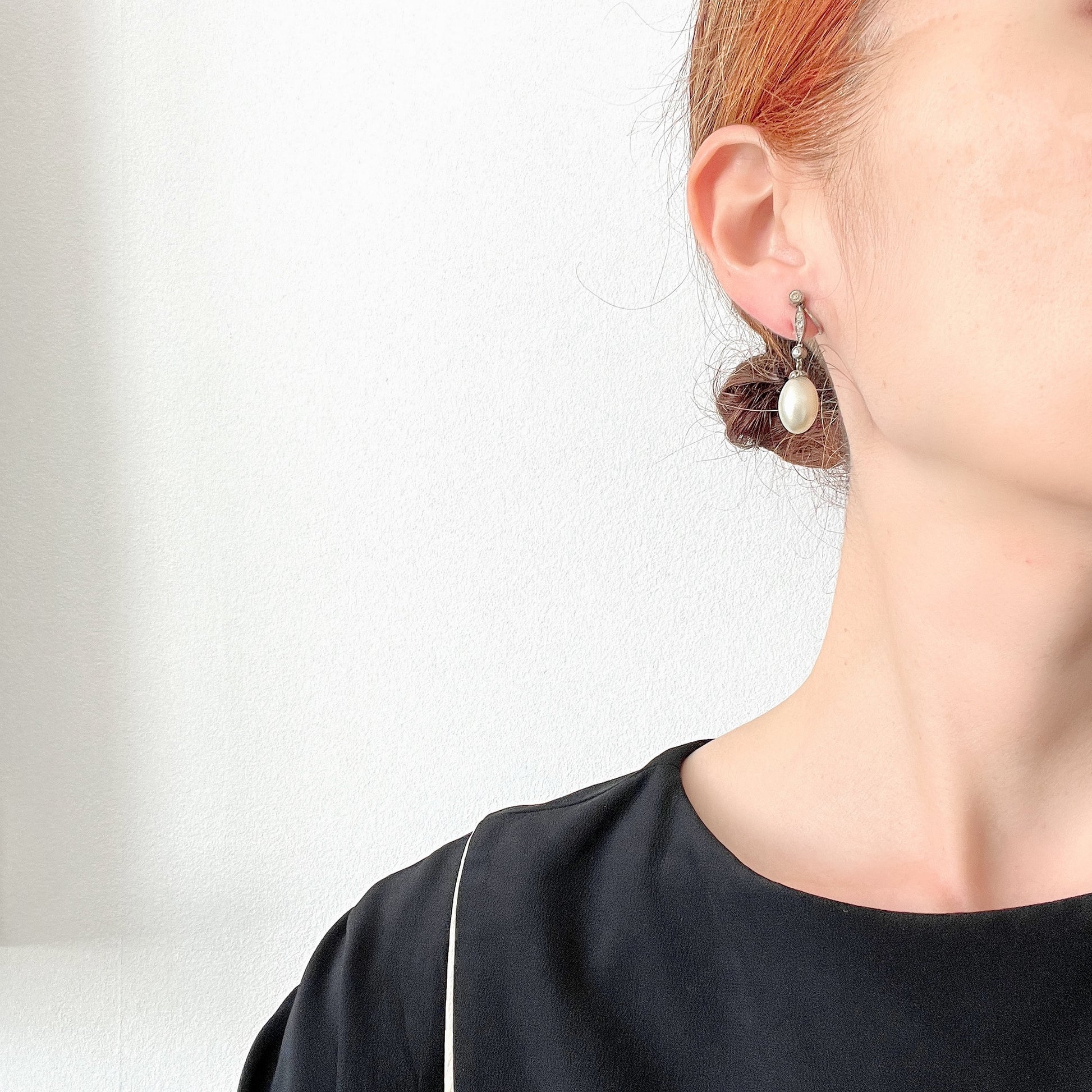  Screw-back earrings featuring oval-shaped glass pearls with a subtle silver-grey tint. うっすらとシルバー/グレーみがかかったオーバル型のグラスパールが揺れるスクリューイヤリング。