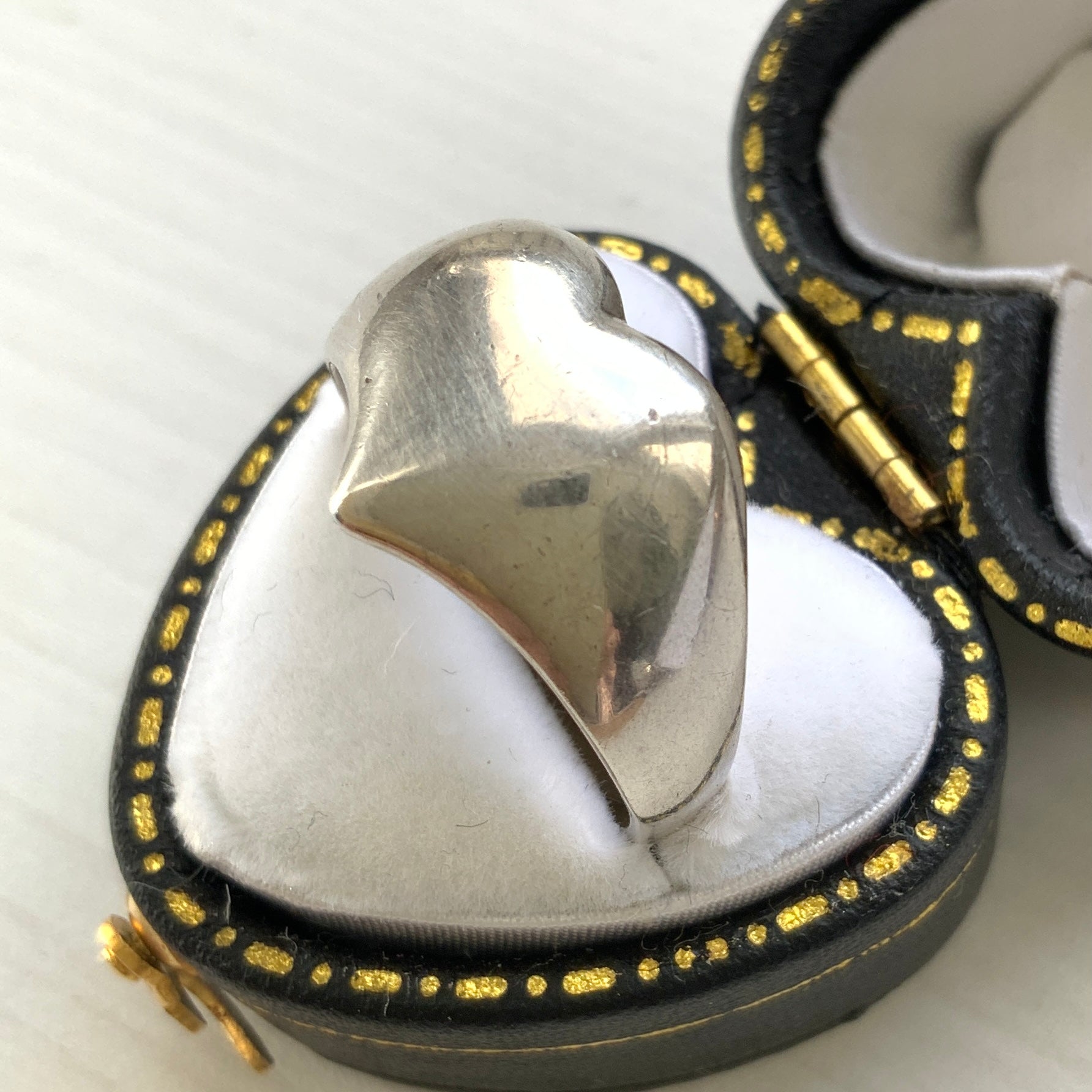 A silver ring shaped into a heart motif with smooth, flowing curves. 滑らかな曲線でハートモチーフに仕立てられたシルバーリング。