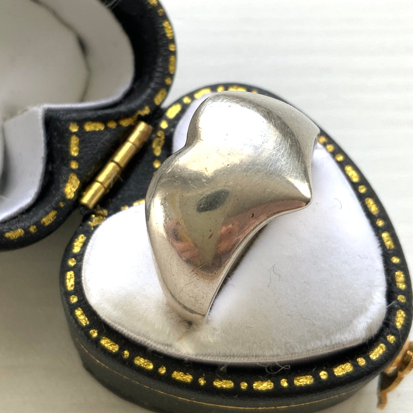 A silver ring shaped into a heart motif with smooth, flowing curves. 滑らかな曲線でハートモチーフに仕立てられたシルバーリング。
