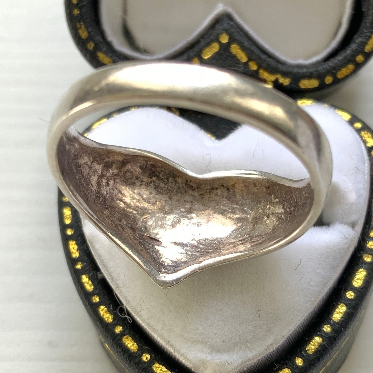 A silver ring shaped into a heart motif with smooth, flowing curves. 滑らかな曲線でハートモチーフに仕立てられたシルバーリング。