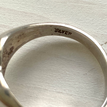 A silver ring shaped into a heart motif with smooth, flowing curves. 滑らかな曲線でハートモチーフに仕立てられたシルバーリング。