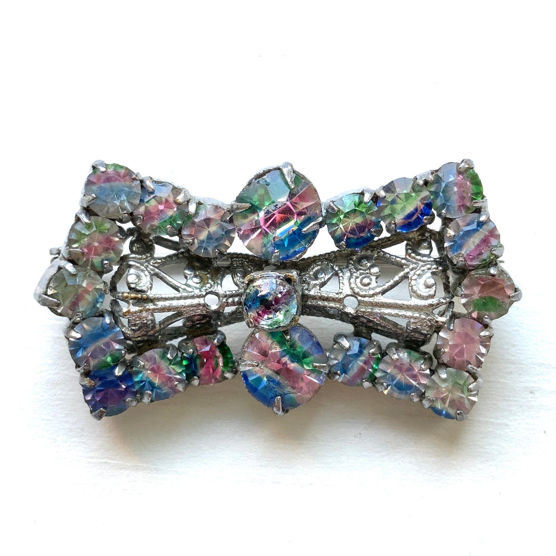 Vintage bow-shaped brooch set with iris glass stones. アイリスグラスがあしらわれた、リボンシェイプのブローチ。