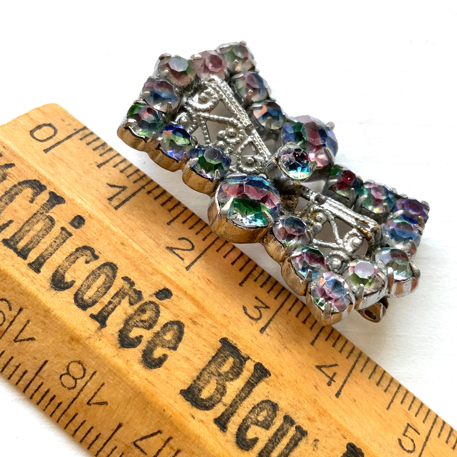 Vintage bow-shaped brooch set with iris glass stones. アイリスグラスがあしらわれた、リボンシェイプのブローチ。