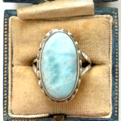 A silver ring featuring an oval-shaped larimar stone with a beautiful pattern reminiscent of rippling water. まるで水面のような美しい模様が入ったオーバル型ラリマーのシルバーリング。