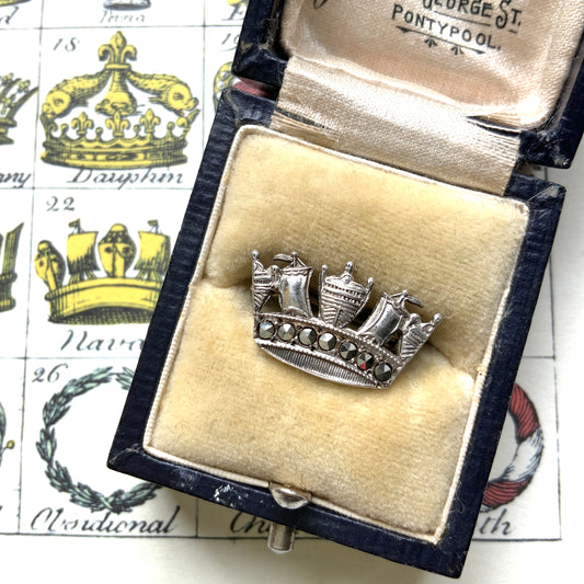 A silver brooch featuring a naval crown decorated with marcasite. マーカサイトがあしらわれた海軍王冠のシルバーのブローチ。