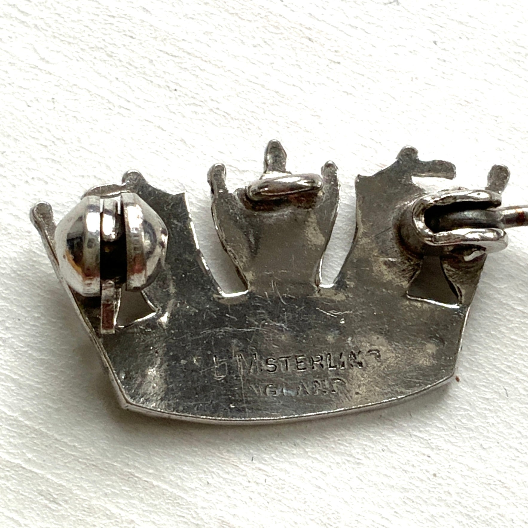 A silver brooch featuring a naval crown decorated with marcasite. マーカサイトがあしらわれた海軍王冠のシルバーのブローチ。