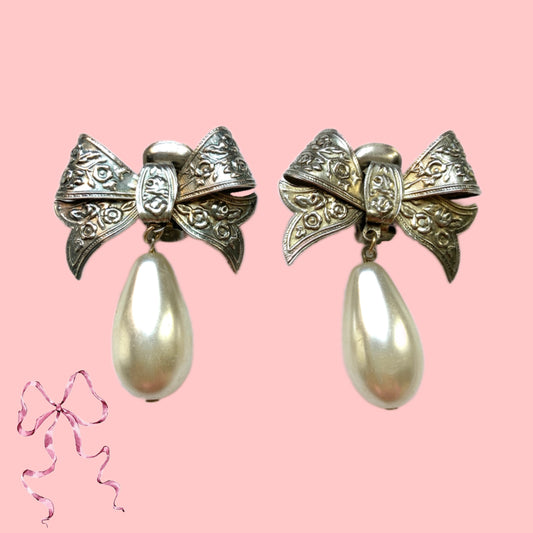 Vintage clip-on earrings featuring a silver-tone bow with large teardrop pearls that gently sway. シルバートーンメタルのリボンに、大きなティアドロップパールが揺れるクリップイヤリング。