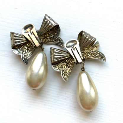 Vintage clip-on earrings featuring a silver-tone bow with large teardrop pearls that gently sway. シルバートーンメタルのリボンに、大きなティアドロップパールが揺れるクリップイヤリング。
