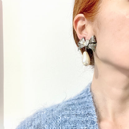 Vintage clip-on earrings featuring a silver-tone bow with large teardrop pearls that gently sway. シルバートーンメタルのリボンに、大きなティアドロップパールが揺れるクリップイヤリング。
