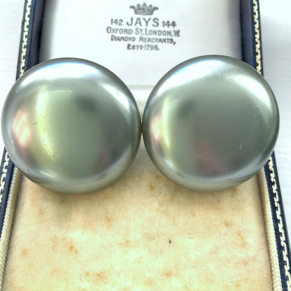 A pair of Napier clip-on earrings featuring large pearl buttons in a deep grey tone. 深みのあるグレーカラーが印象的な、ネイピアの大粒パールボタンのクリップイヤリング。
