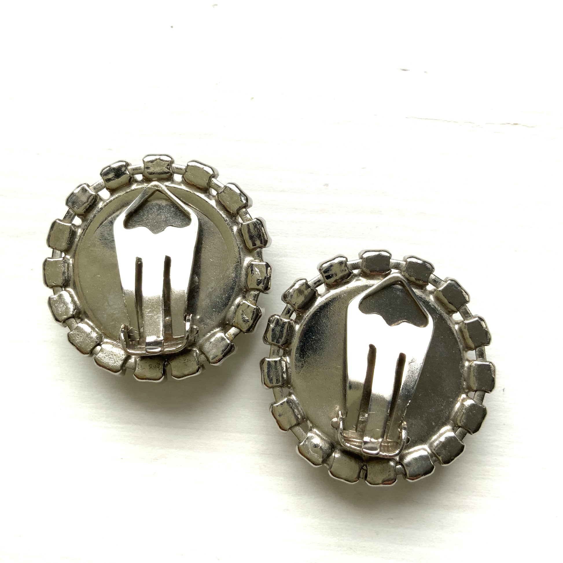 Vintage earrings featuring a flat pearl button surrounded by a halo of clear stones.  フラットなパールボタンの周りを、クリアストーンがぐるりと囲むヴィンテージイヤリング