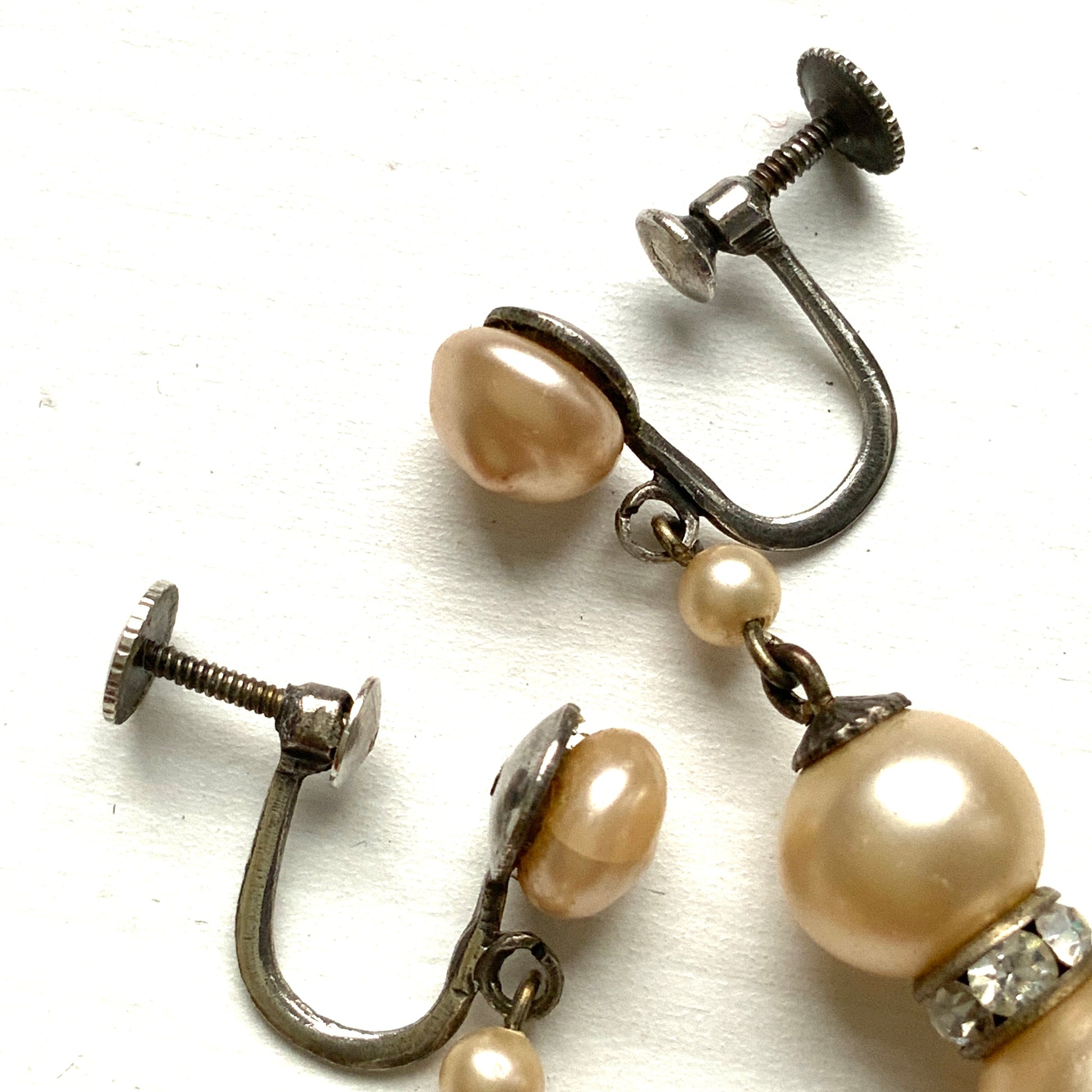Cream-coloured glass pearls dangle from these screw-back earrings.  クリームカラーのグラスパールがゆれるスクリューイヤリング。