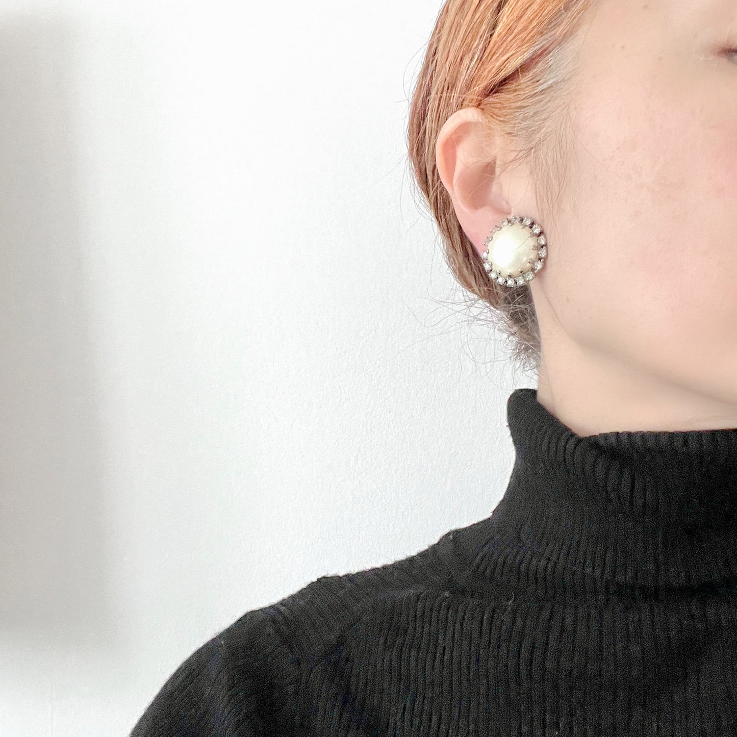 Vintage earrings featuring a flat pearl button surrounded by a halo of clear stones.  フラットなパールボタンの周りを、クリアストーンがぐるりと囲むヴィンテージイヤリング