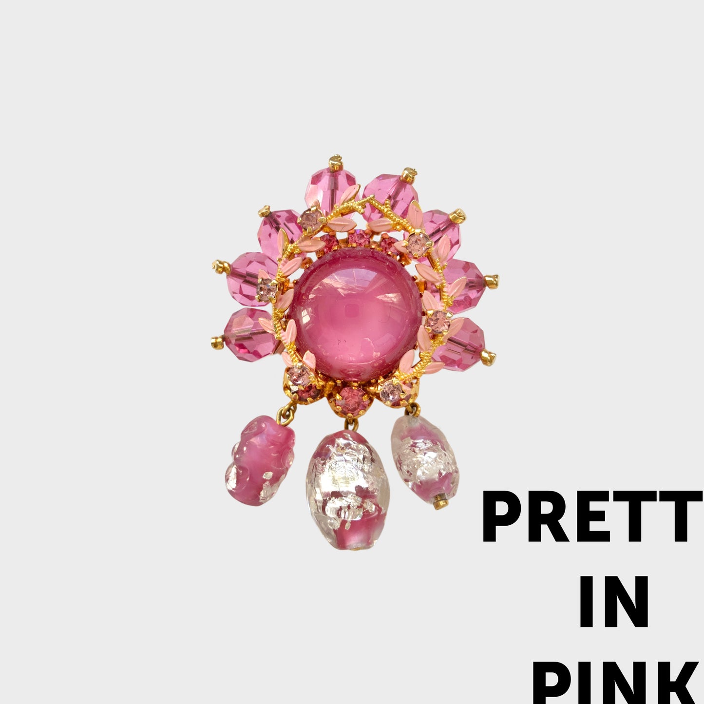 A brooch in soft pink tones, featuring a richly layered design. ピンクのトーンでまとめられた、印象的なデザインのブローチ。