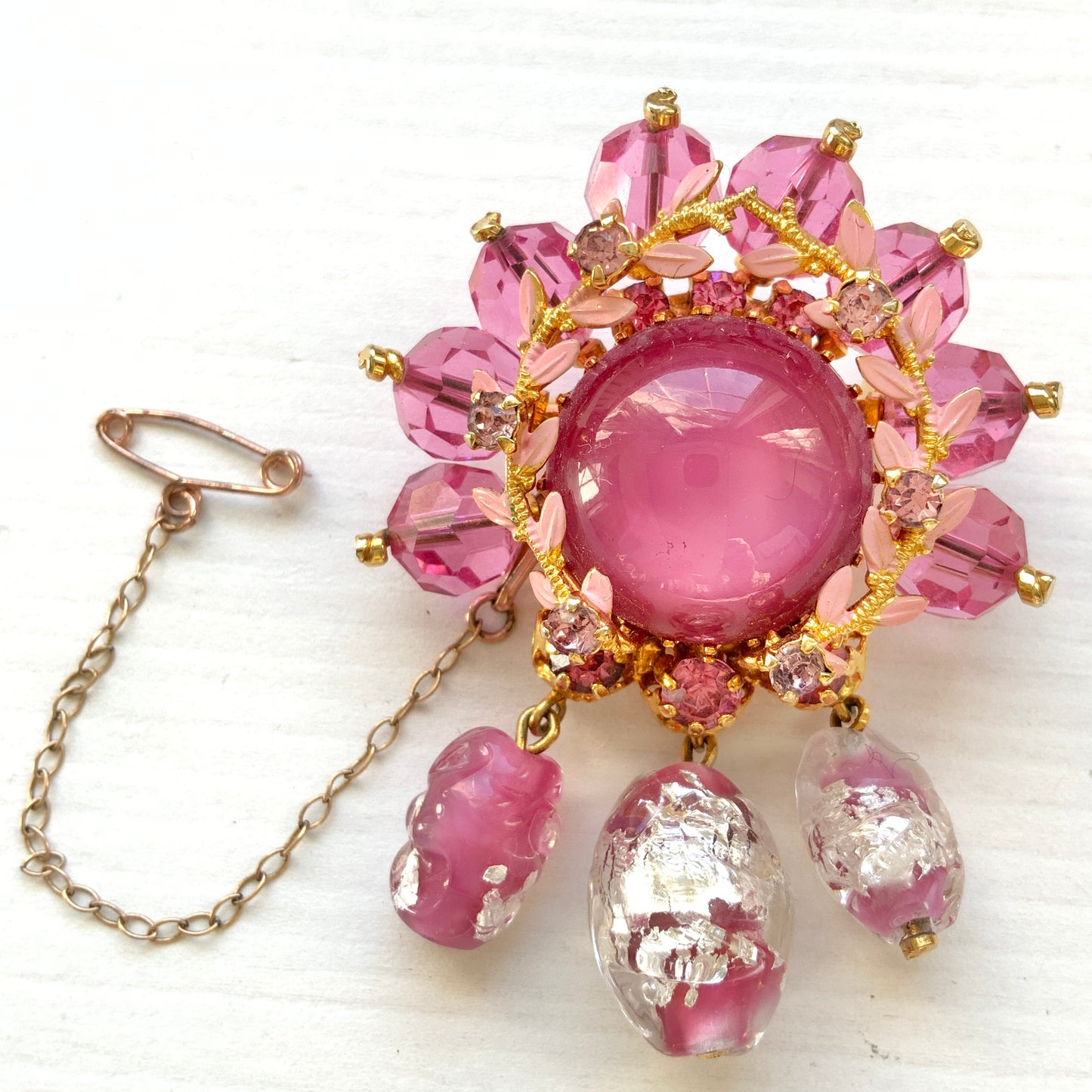 A brooch in soft pink tones, featuring a richly layered design. ピンクのトーンでまとめられた、印象的なデザインのブローチ。