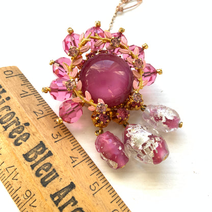 A brooch in soft pink tones, featuring a richly layered design. ピンクのトーンでまとめられた、印象的なデザインのブローチ。