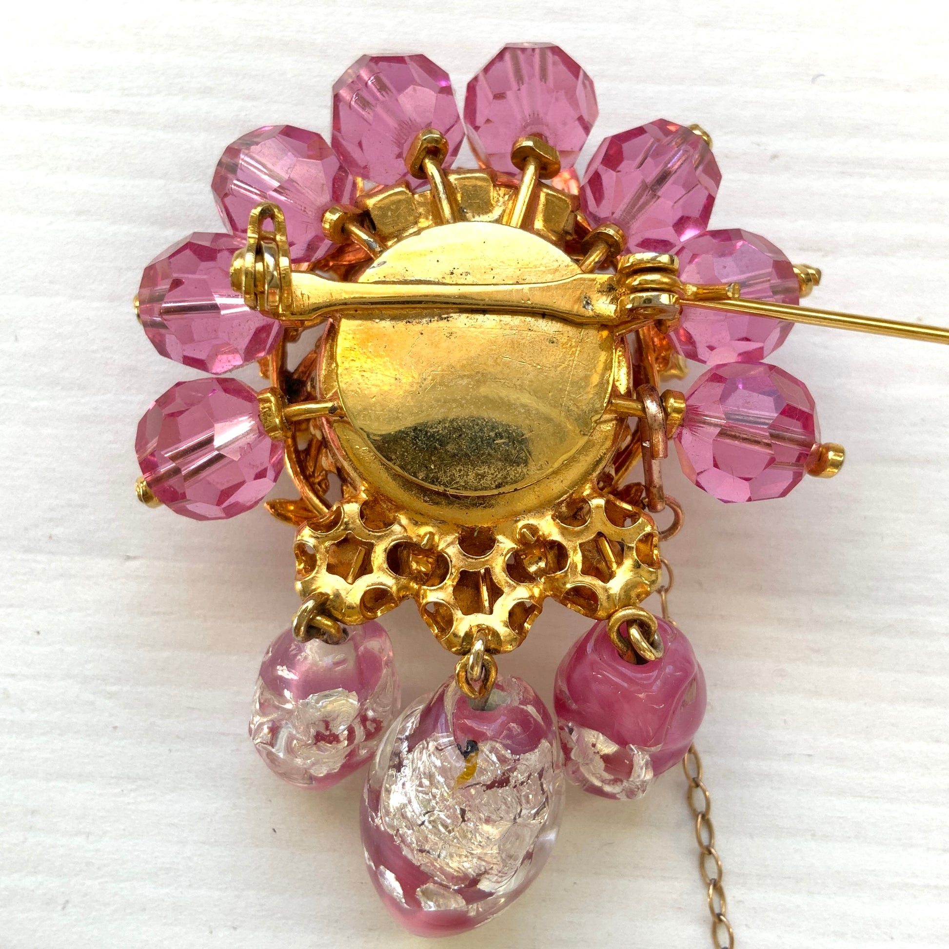 A brooch in soft pink tones, featuring a richly layered design. ピンクのトーンでまとめられた、印象的なデザインのブローチ。