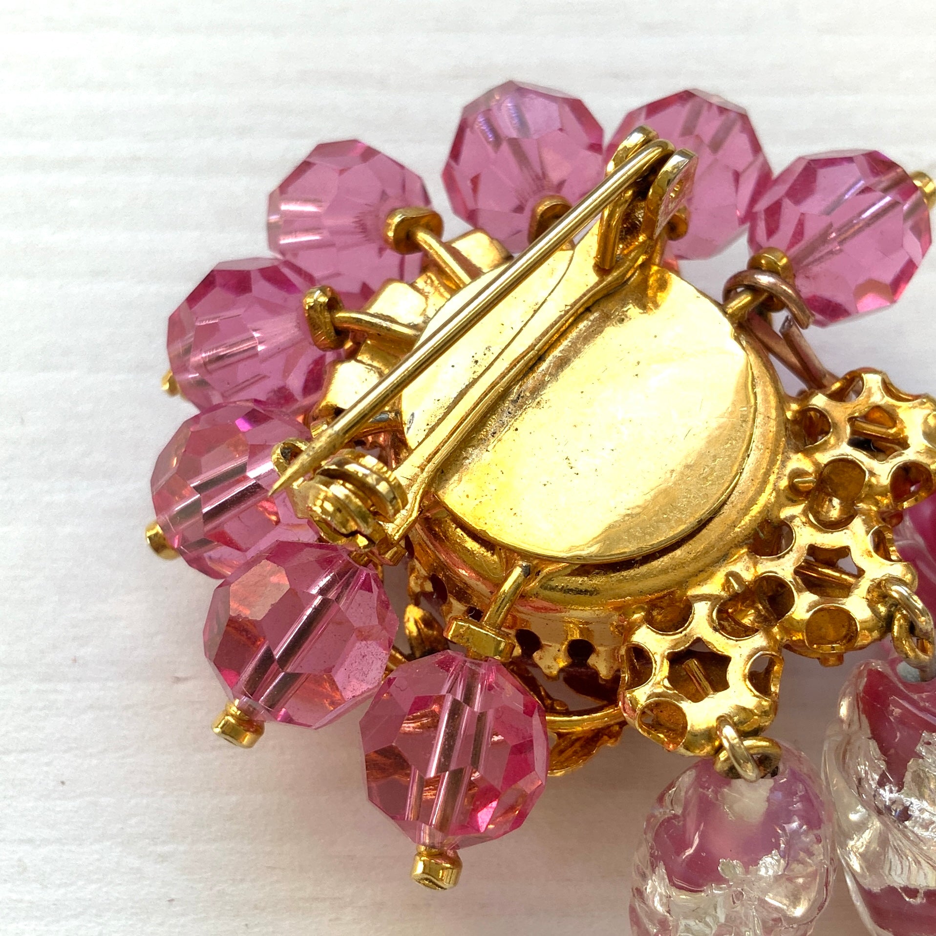 A brooch in soft pink tones, featuring a richly layered design. ピンクのトーンでまとめられた、印象的なデザインのブローチ。