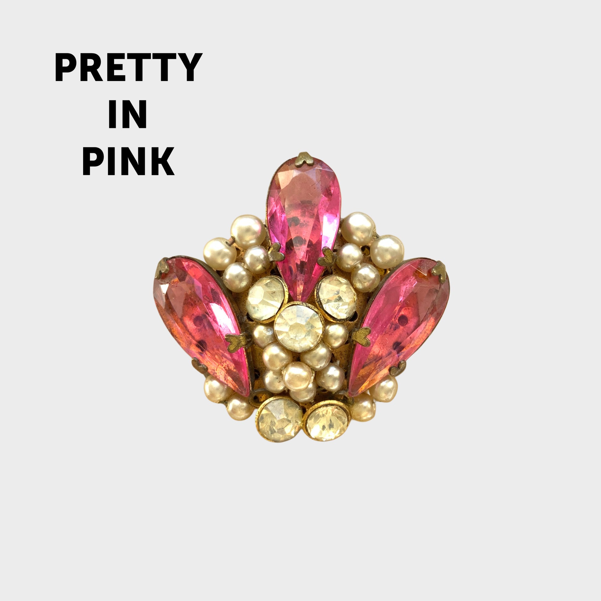 A brooch featuring pink glass, faux pearls and rhinestones. ピンクのガラスとガラスパール、ラインストーンを組み合わせたブローチ。