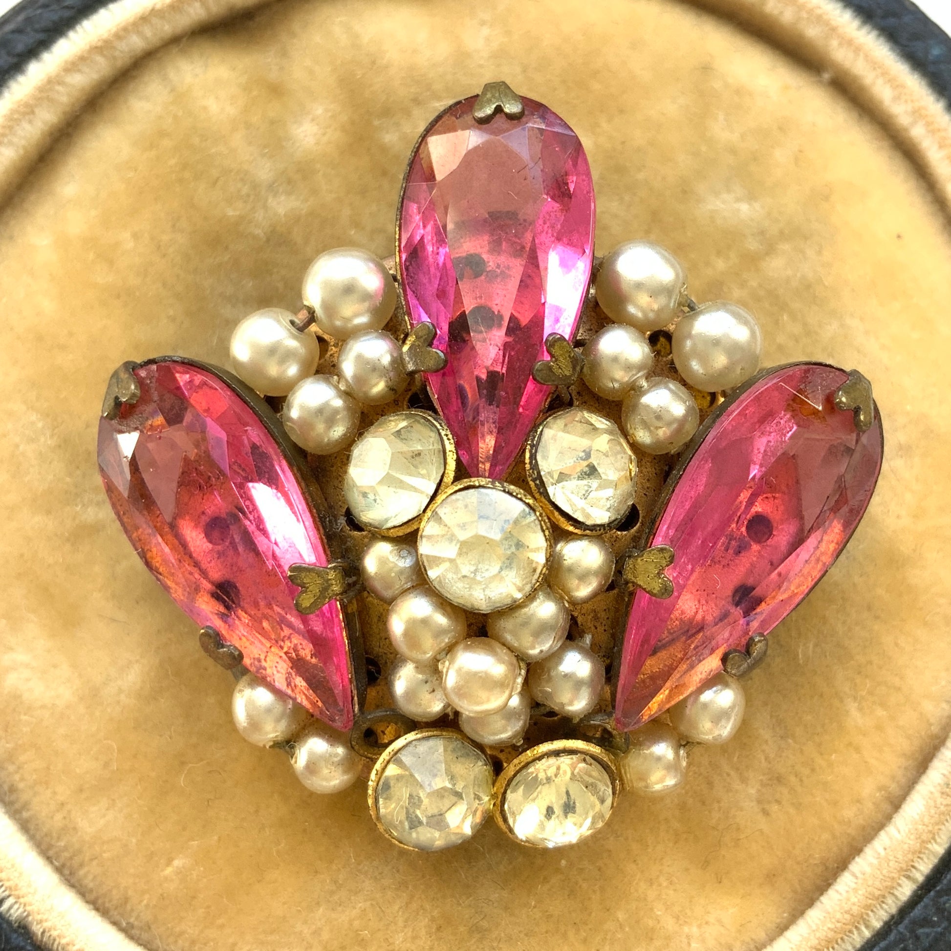 A brooch featuring pink glass, faux pearls and rhinestones. ピンクのガラスとガラスパール、ラインストーンを組み合わせたブローチ。