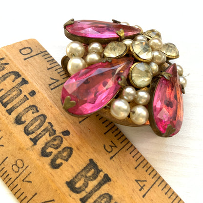 A brooch featuring pink glass, faux pearls and rhinestones. ピンクのガラスとガラスパール、ラインストーンを組み合わせたブローチ。