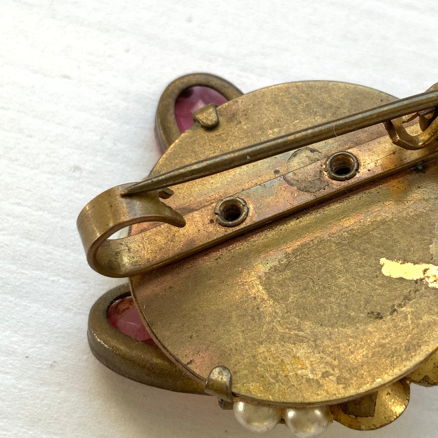 A brooch featuring pink glass, faux pearls and rhinestones. ピンクのガラスとガラスパール、ラインストーンを組み合わせたブローチ。