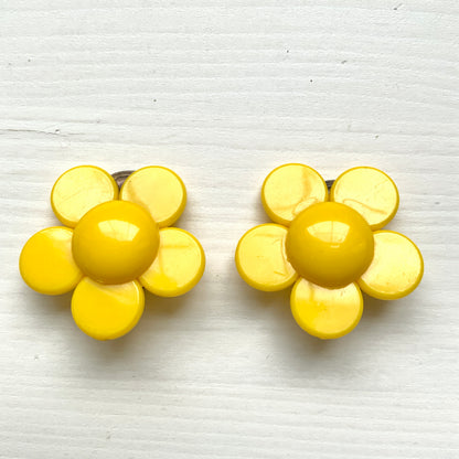 Flower clip-on earrings in a vivid buttery yellow tone.  バターのようなビビッドイエローのお花のクリップイヤリング。