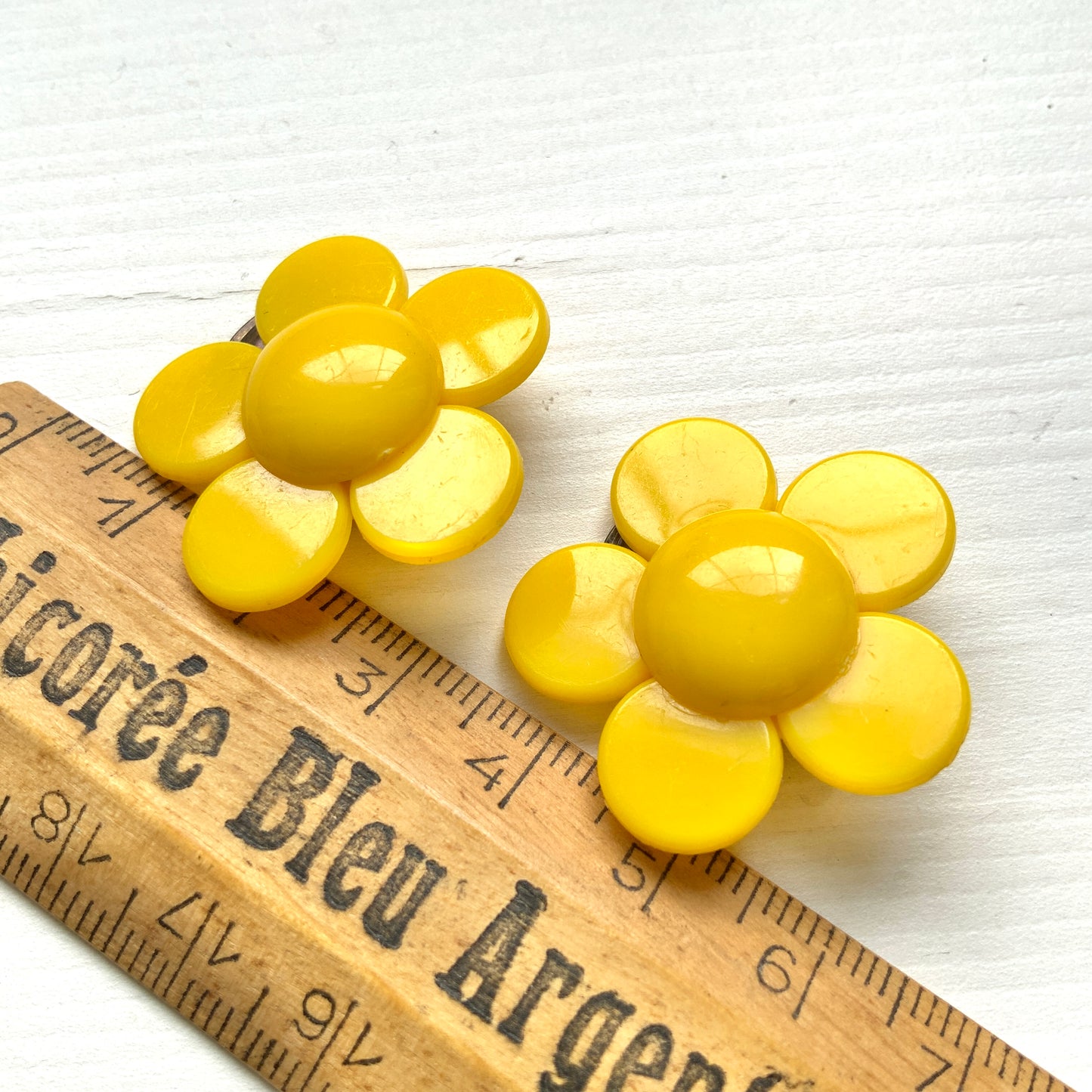 Flower clip-on earrings in a vivid buttery yellow tone.  バターのようなビビッドイエローのお花のクリップイヤリング。