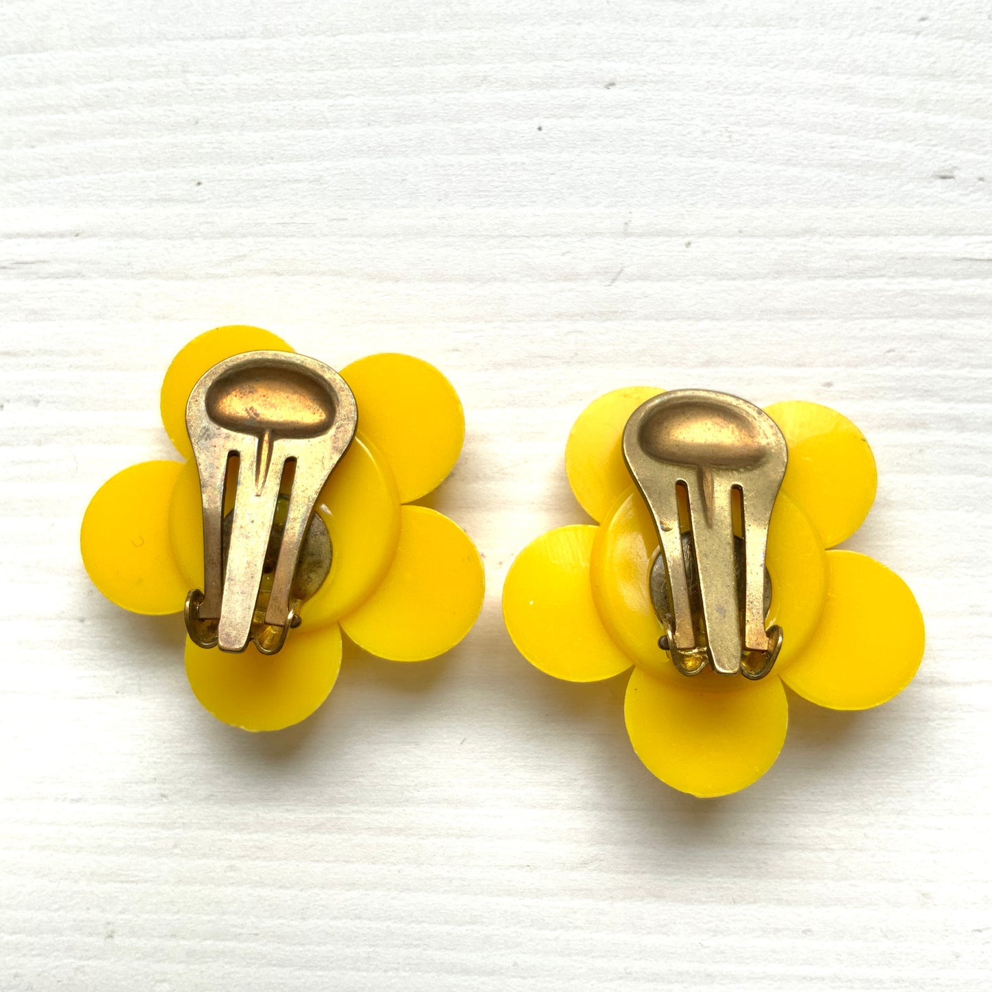 Flower clip-on earrings in a vivid buttery yellow tone.  バターのようなビビッドイエローのお花のクリップイヤリング。